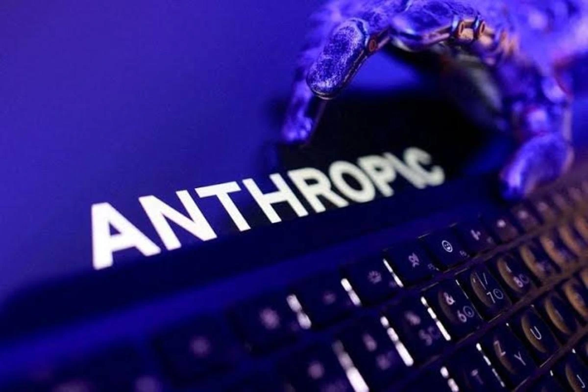 Anthropic yazılı ekrana ve klavyeye uzanan robotik el