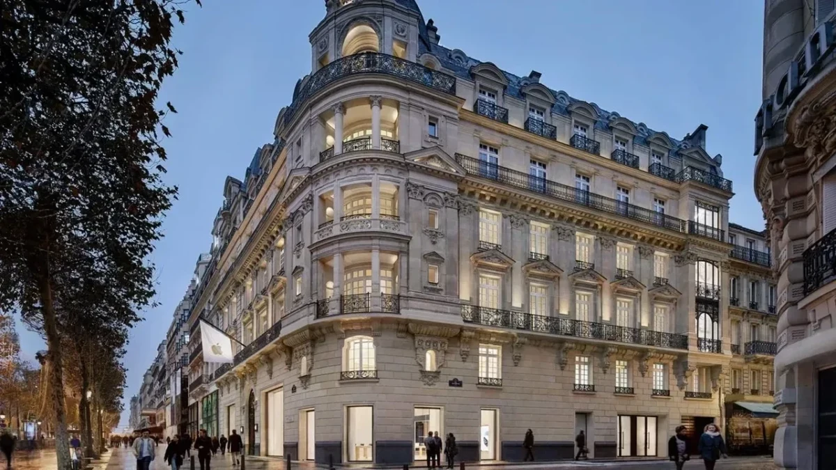 Paris’te Apple mağazasının bulunduğu, aydınlatılmış cepheli tarihi köşe binası ve önünden geçen yayalar