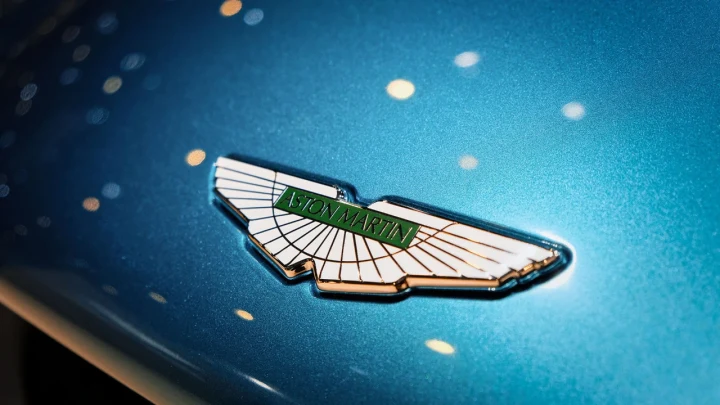 Mavi renkli otomobil kaportası üzerinde Aston Martin amblemi