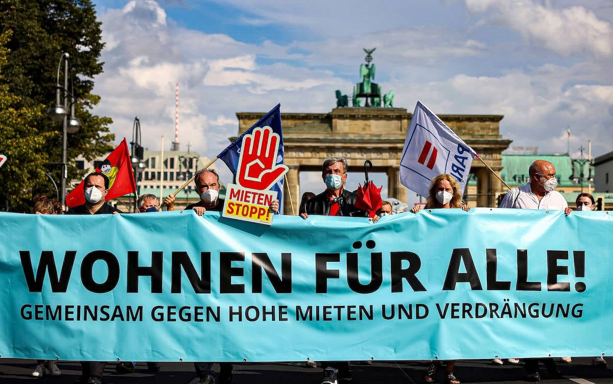 Berlin’de Brandenburg Kapısı önünde yüksek kiralara karşı pankart taşıyan protestocular