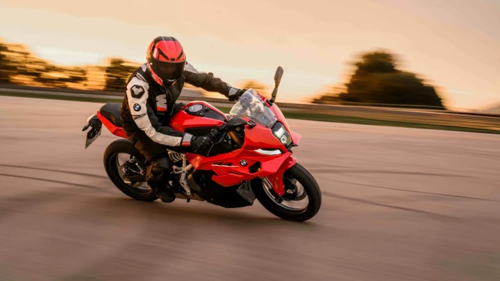 Kırmızı BMW motosiklet üzerinde viraj alan kasklı sürücü