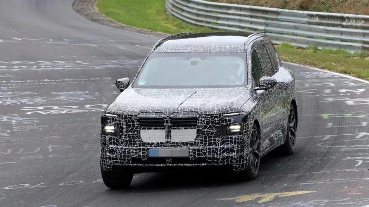 Kamuflajlı BMW iX7 test aracı önden görüntüleniyor