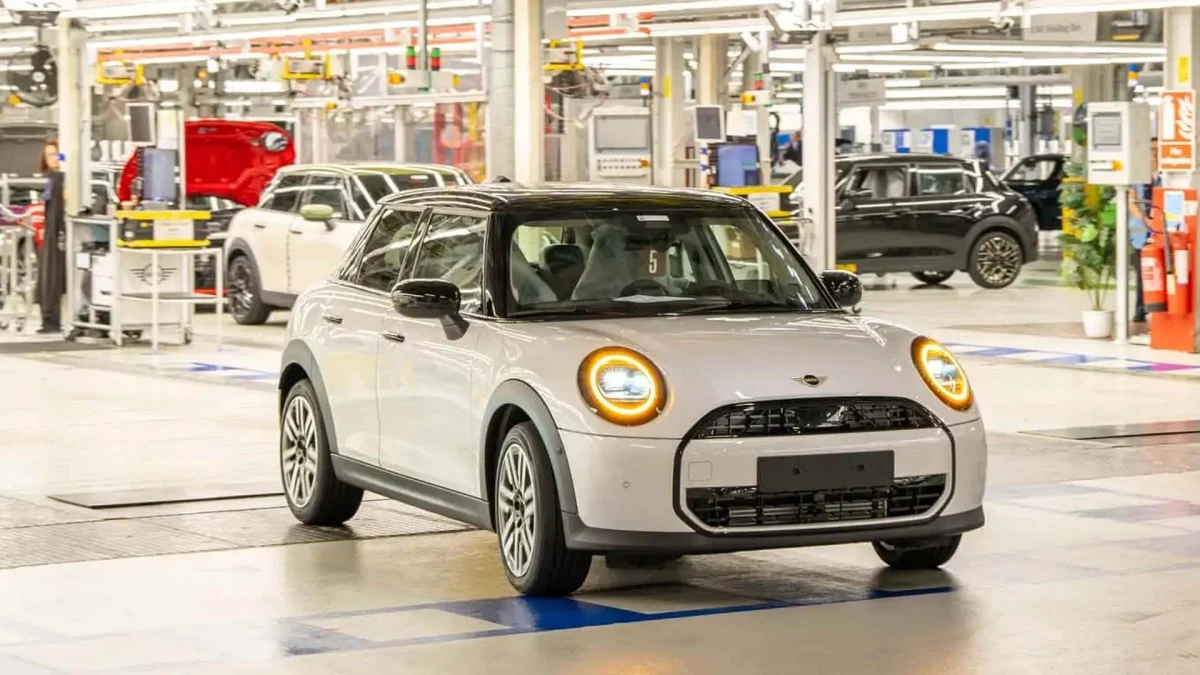 Fabrika üretim alanında bulunan beyaz Mini Cooper ve arka plandaki diğer araçlar