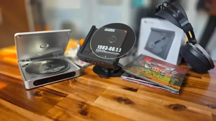 Ahşap masa üzerinde taşınabilir CD çalarlar, CD koleksiyonu ve kulaklıklar