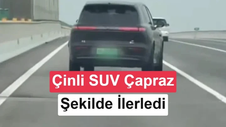 Otoyolda çapraz konumda ilerleyen koyu renkli SUV’un arkadan görünümü