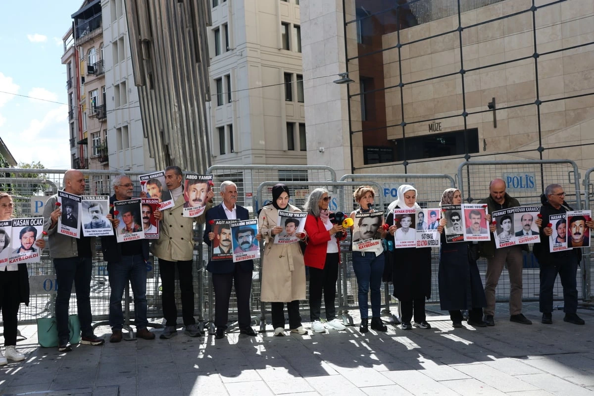 Cumartesi Anneleri/İnsanları üyeleri ve destekçileri, kaybedilen yakınlarının fotoğraflarıyla bariyerler önünde bir arada