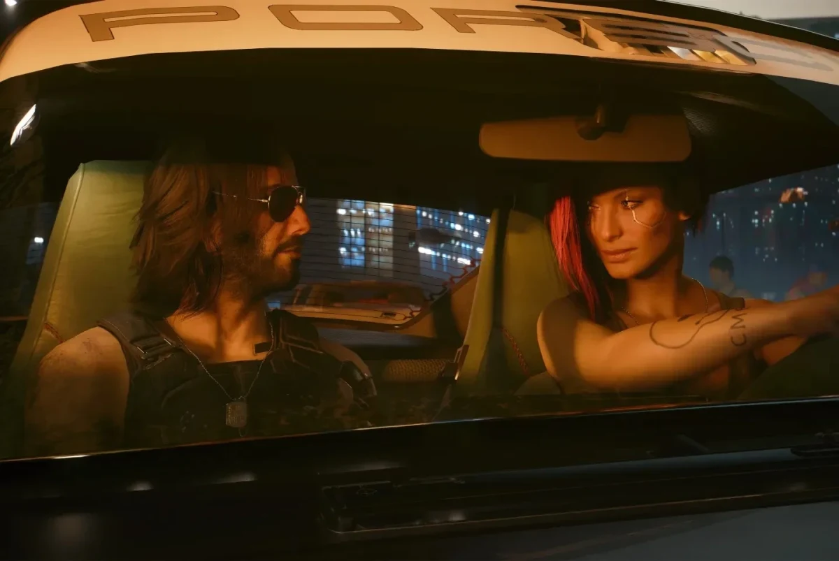 Cyberpunk 2077’den bir sahnede, gece kentinde bir aracın içinde oturan iki karakter