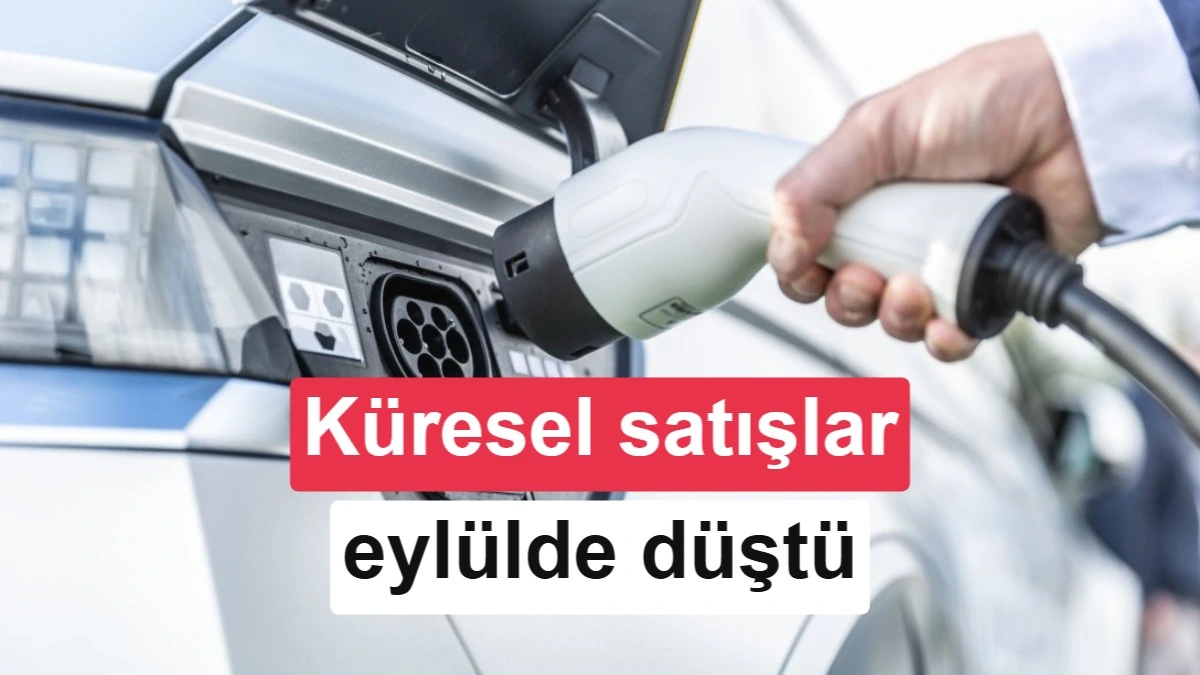 Elektrikli araç şarj kablosunu araca takan bir el; görsel üzerinde küresel satışların eylülde düştüğü yazıyor