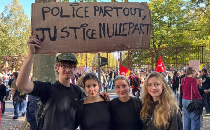 Fransa’daki protestoda dört genç, üzerinde “Her yerde polis, hiçbir yerde adalet” yazan dövizle poz veriyor.