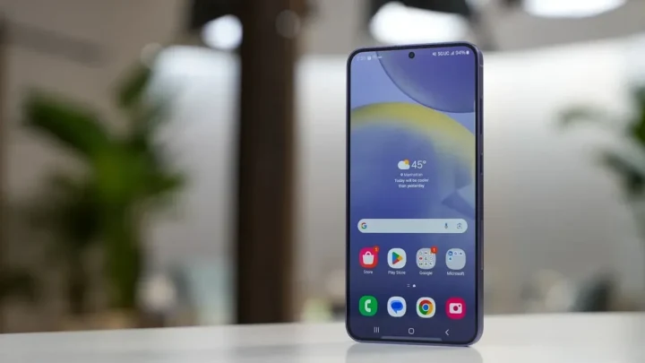 Samsung Galaxy akıllı telefon, ana ekranda uygulama simgeleriyle masa üzerinde duruyor