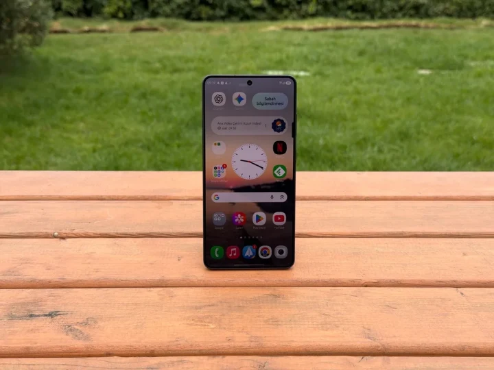 Ahşap bir yüzey üzerinde ekranı açık duran Samsung akıllı telefon