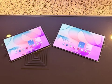 Samsung Galaxy Tab S12+ ve Tab S12 Ultra yan yana, ekranlarında renkli ana ekran arayüzü açık