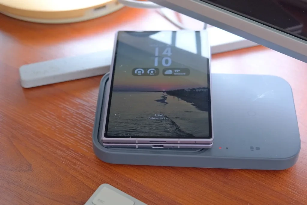 Galaxy Z Fold 8 kapalı halde, masadaki kablosuz şarj aksesuarının üzerinde duruyor