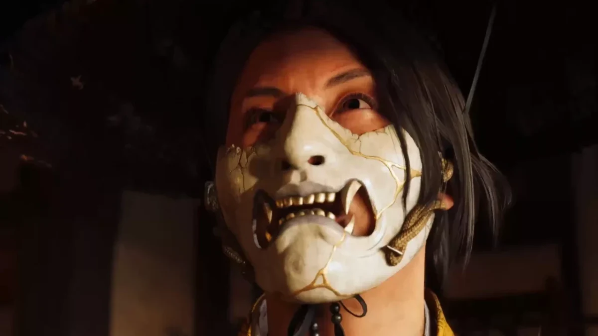 Ghost of Yotei’de beyaz maske takan bir karakterin yakın plan görüntüsü.