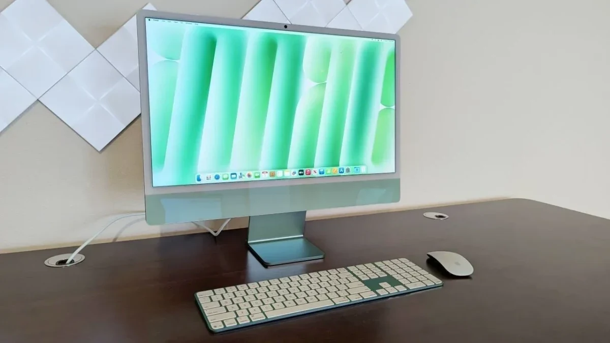 Yeşil tonlu ekrana sahip Apple iMac, klavye ve fareyle birlikte masa üzerinde