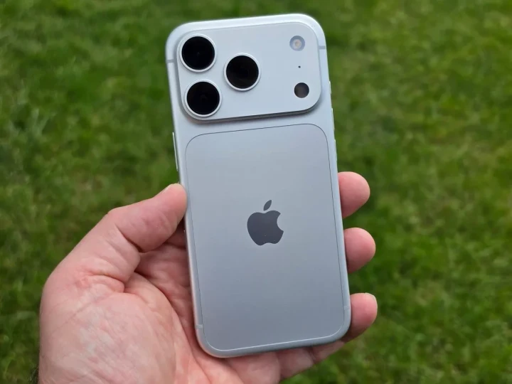 Bir kişinin elinde tuttuğu, arka kamera modülü görünen gümüş renkli Apple telefonu