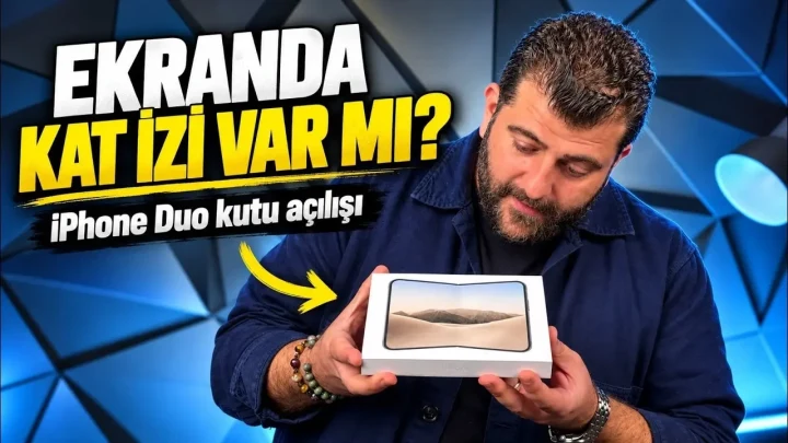 Bir sunucu, iPhone Duo kutusunu elinde tutarak inceliyor; görselde katlanabilir ekranda kat izi olup olmadığı sorusu öne çıkarılıyor.
