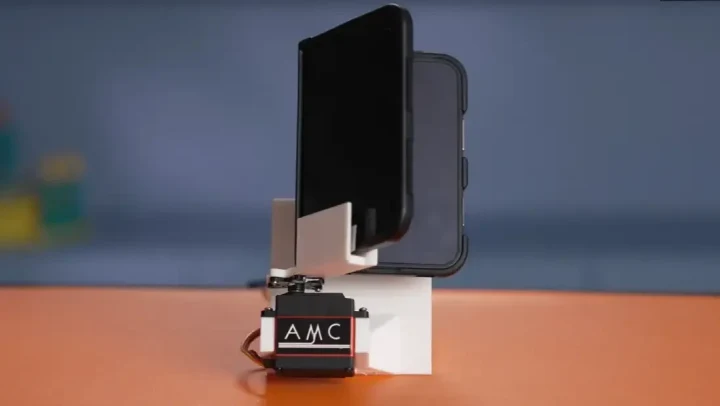 iPhone Duo, menteşe dayanıklılık testi için robot düzeneğine yerleştirilmiş halde