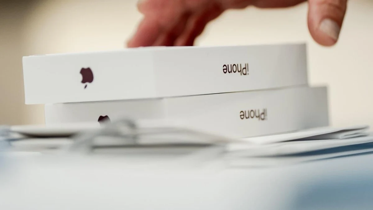 Üst üste duran iPhone kutularından birine uzanan el