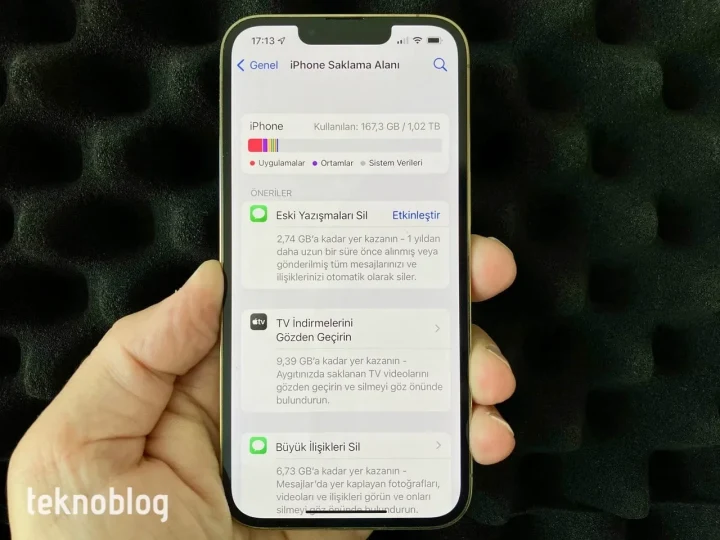 Bir elde tutulan iPhone’un ekranında saklama alanı yönetimi seçenekleri görüntüleniyor.
