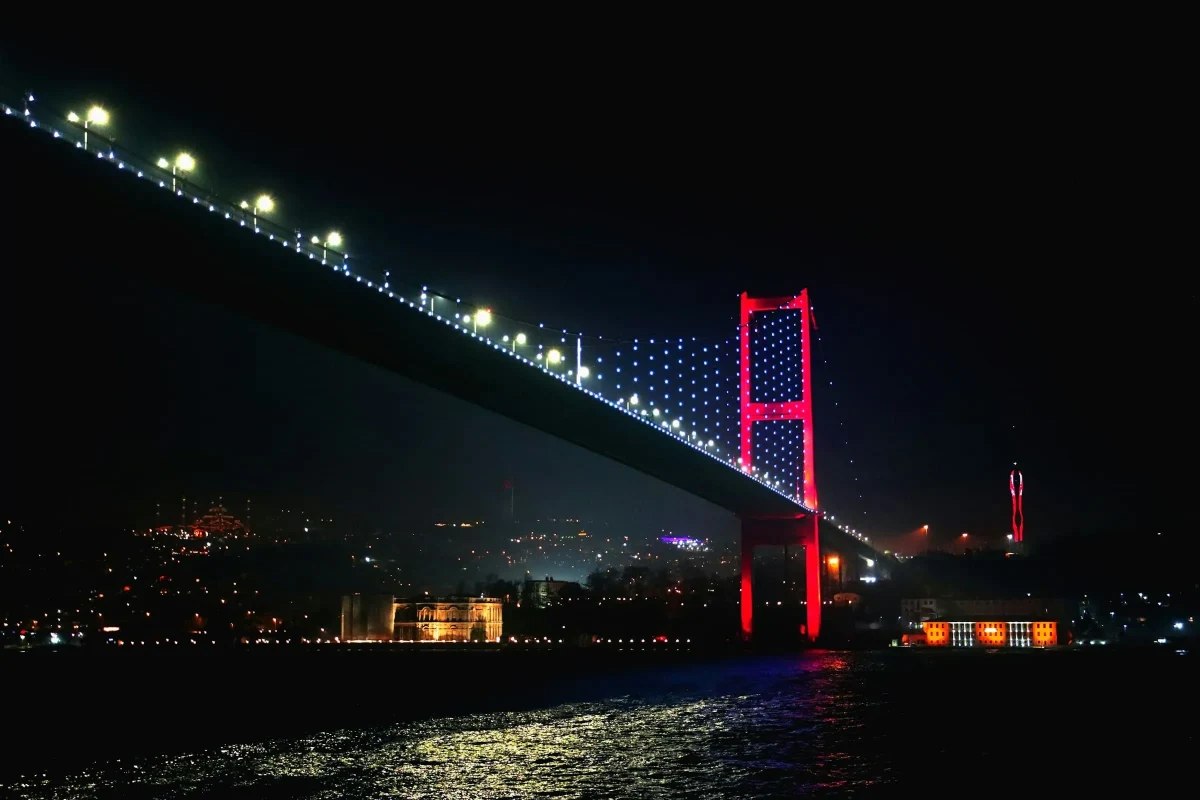 Gece ışıklandırılmış Boğaziçi Köprüsü ve İstanbul manzarası