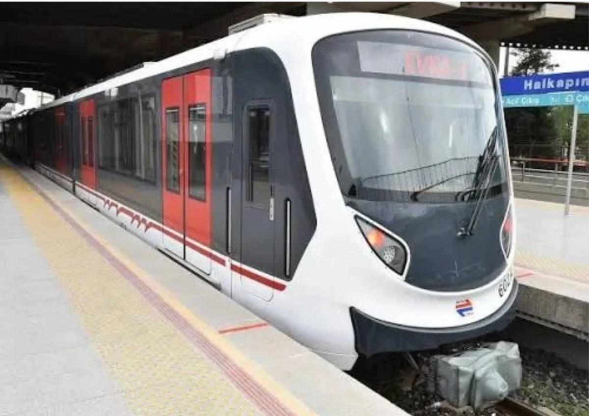 İzmir’de bir metro istasyonunda peronda duran beyaz ve kırmızı renkli metro treni