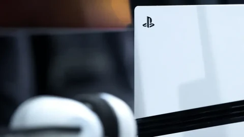 Beyaz PlayStation 5 konsolu ve ön planda bulanık bir oyun kumandası