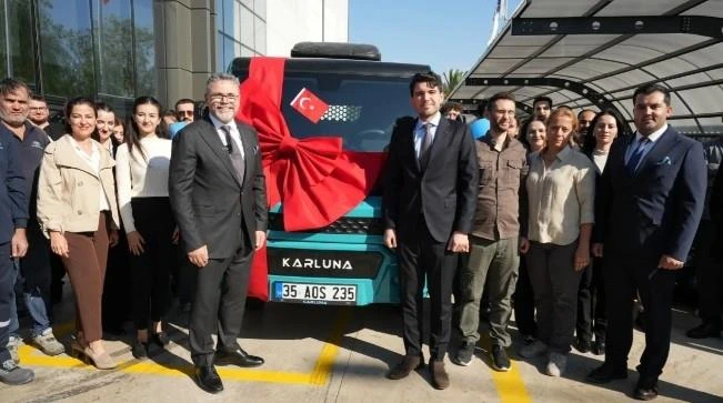 Karluna Pratik aracının önünde kurdele ve Türk bayrağıyla düzenlenen teslimat törenine katılan grup