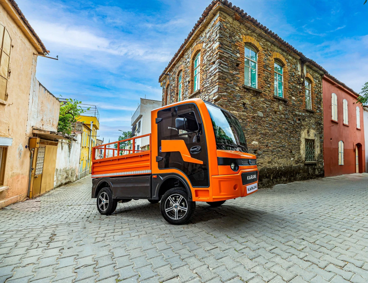 Tarihi taş binaların bulunduğu sokakta sergilenen turuncu Karluna Pratik elektrikli araç