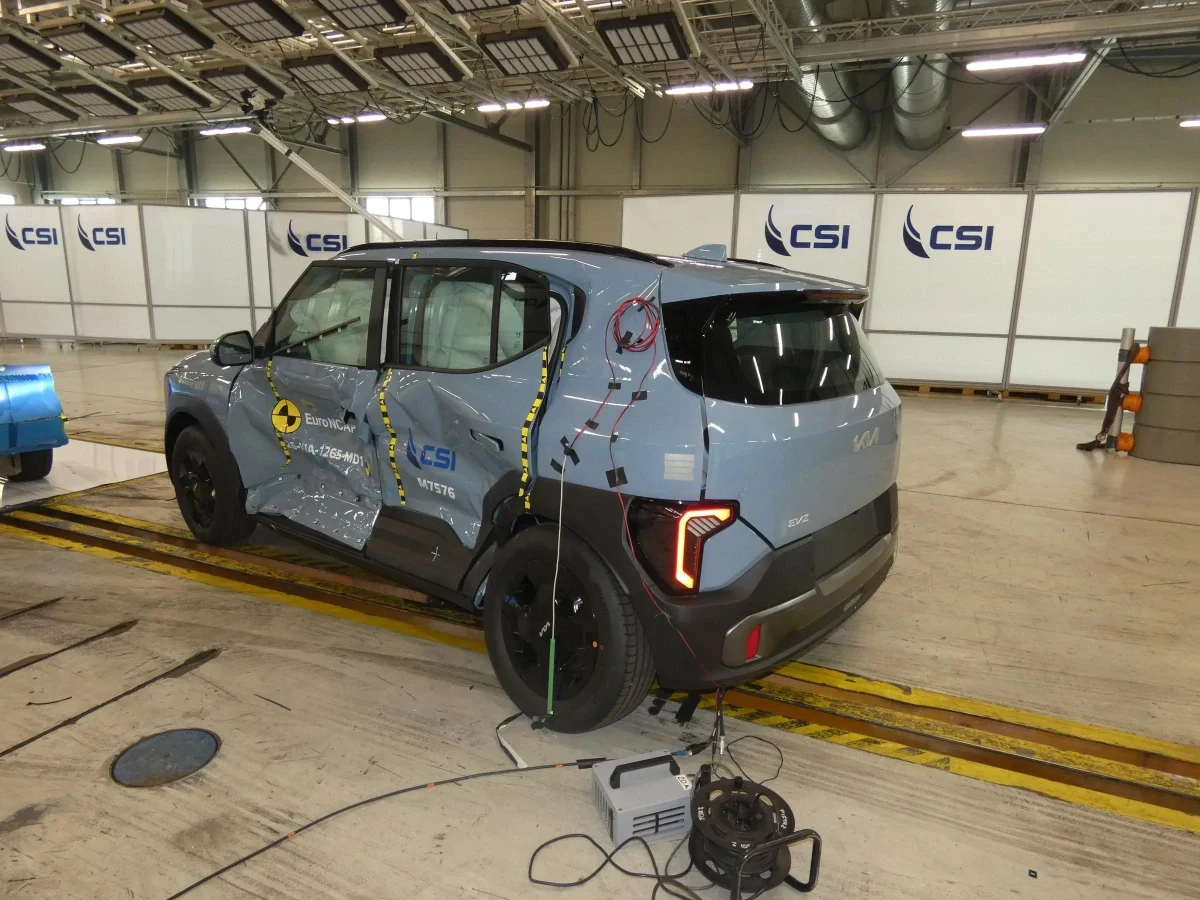 Test alanında arka-yan açıdan görünen gri Kia EV2