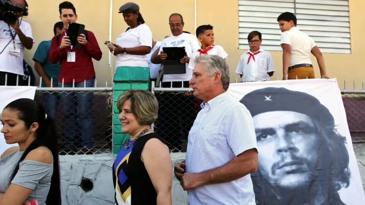 Küba Devlet Başkanı Miguel Diaz-Canel, bir grup insanın önünde Che Guevara portresinin yanından geçiyor
