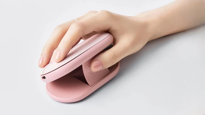 Pembe Logitech Pebble Up fare, yana eğimli kullanım konumunda ve bir el tarafından tutuluyor
