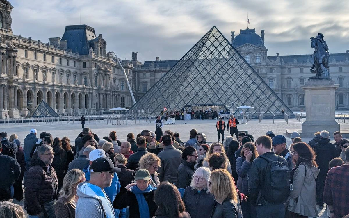 Louvre piramidinin önündeki meydanda bir araya gelen kalabalık