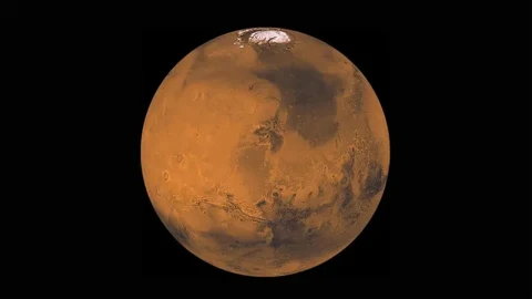 Siyah arka plan önünde turuncu ve kahverengi yüzeyiyle Mars gezegeni
