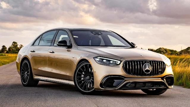 Açık renkli Mercedes-Benz sedan yolda park hâlinde