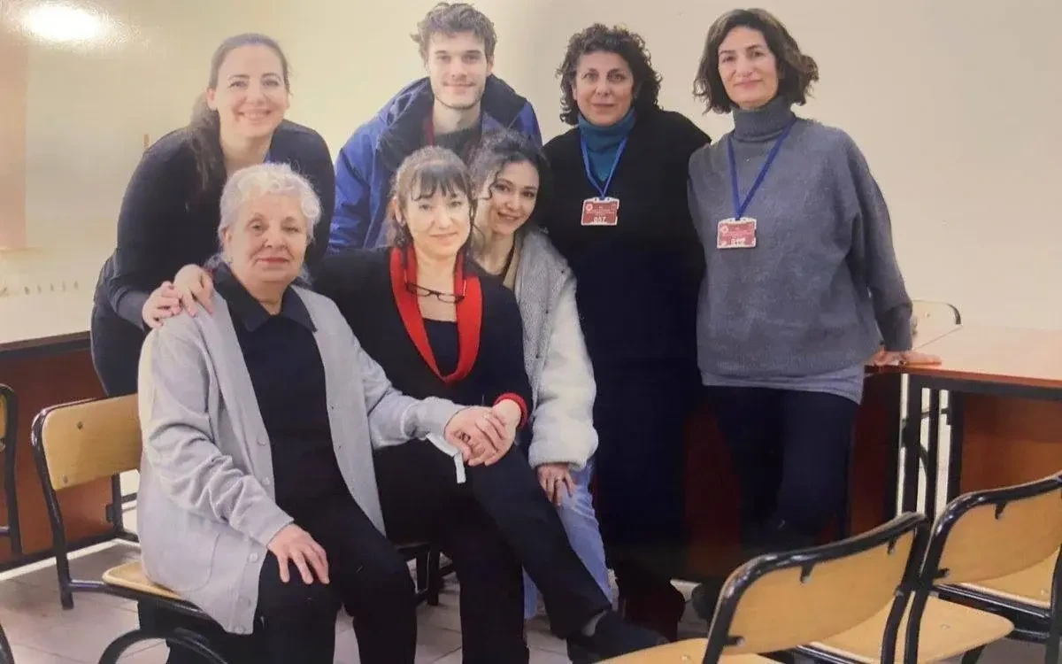 Bir odada birlikte poz veren yedi kişi
