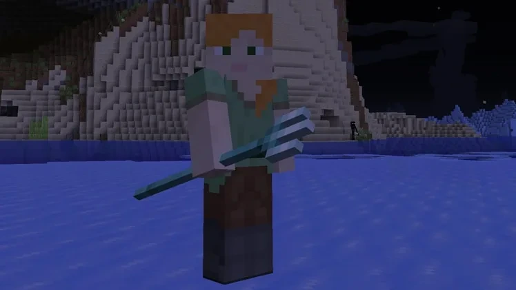 Minecraft’ta elinde Üçlü Mızrak tutan oyuncu su kenarında duruyor