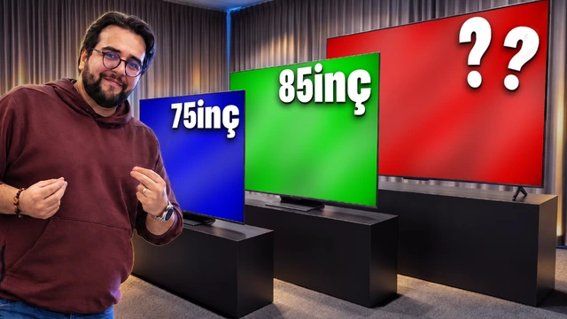 Bir sunucu, farklı ekran boyutları ve renklerde görüntü veren üç televizyonun önünde duruyor.
