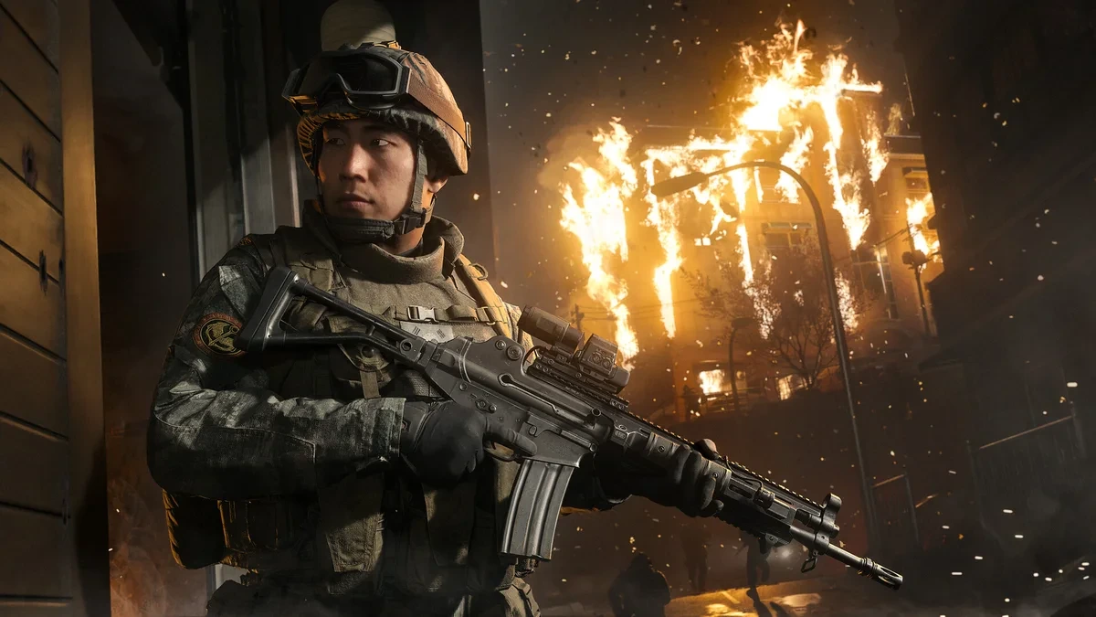 Modern Warfare 4’te Güney Koreli asker Er Park, yanan yapıların önünde tüfeğini tutuyor