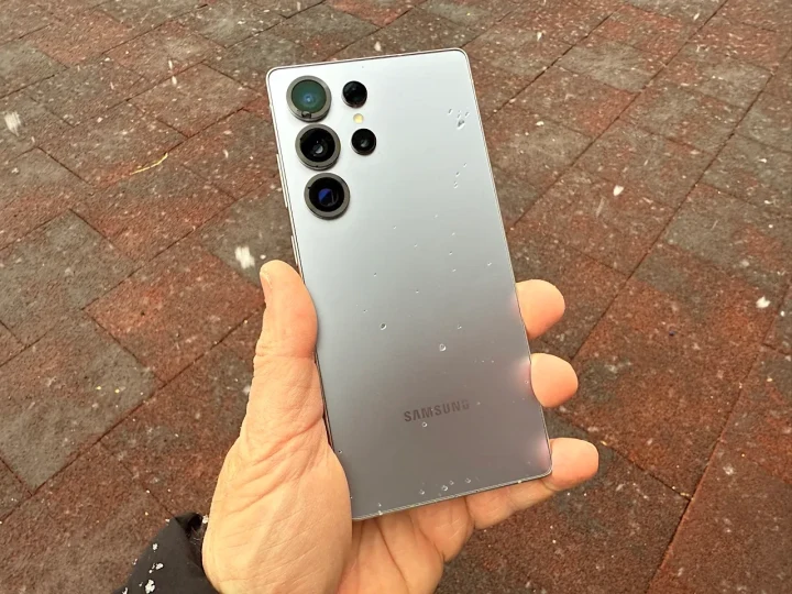 Bir kişinin elinde tuttuğu, arka yüzü görünen Samsung Galaxy telefonu