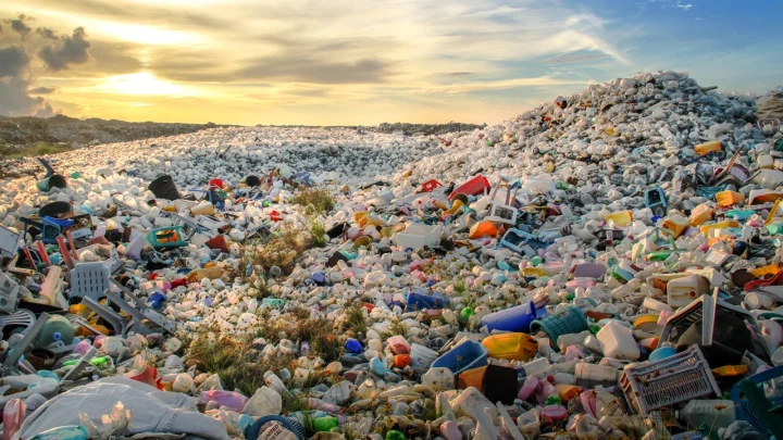Gökyüzünün altında geniş bir alana yayılmış plastik atık yığını