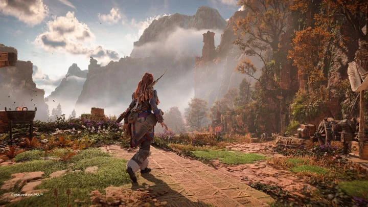 Aloy, Horizon Forbidden West’te dağlık ve yeşil bir arazide ilerliyor