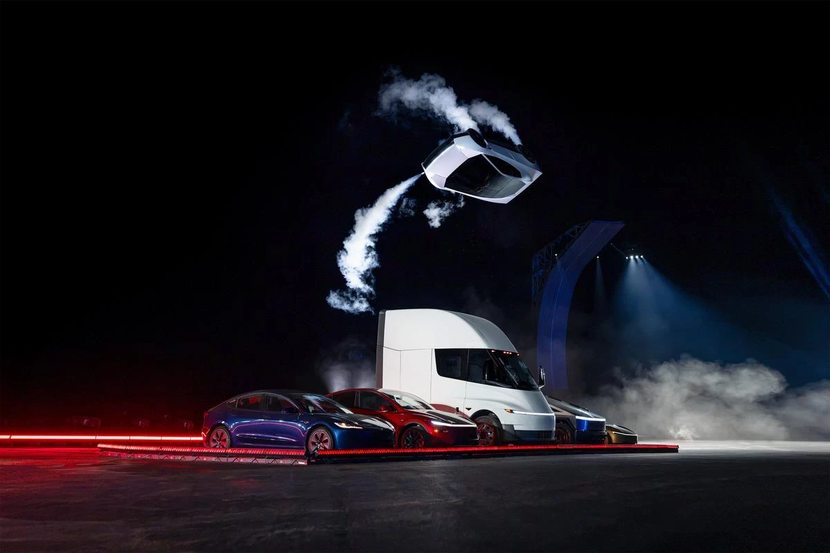Tesla Roadster, etkinlik sahnesinde araçların üzerinde havada manevra yaparken.
