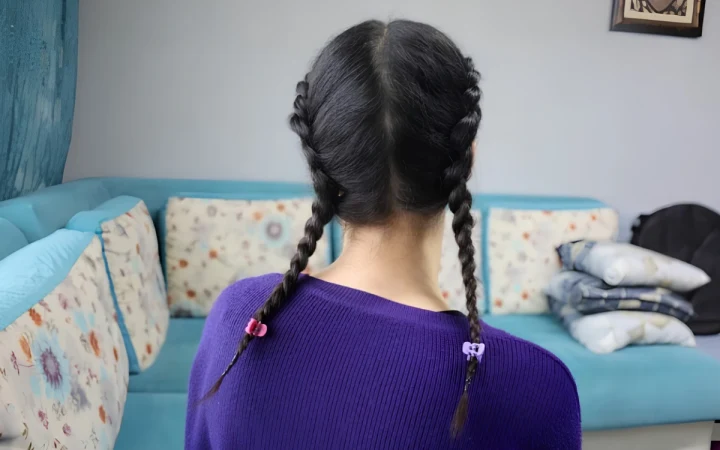 Arkadan görünen, saçları iki örgü yapılmış kişi