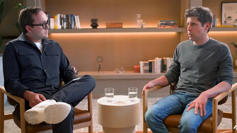 Sam Altman ve bir başka kişinin karşılıklı oturduğu söyleşi görüntüsü
