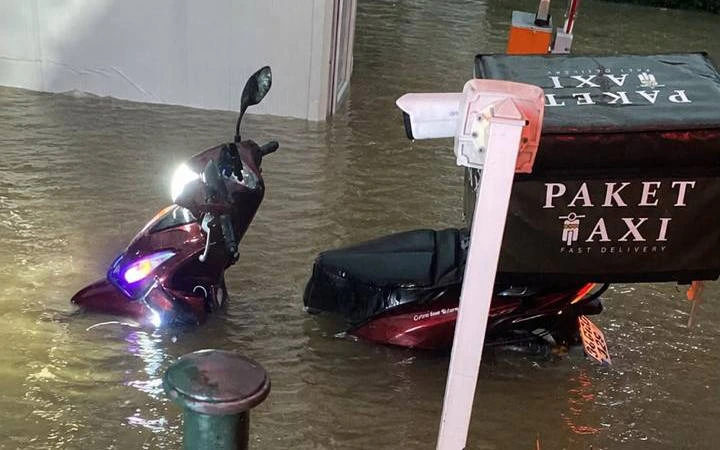 Sel sularının içinde kalan iki motosiklet ve paket taşıma çantası