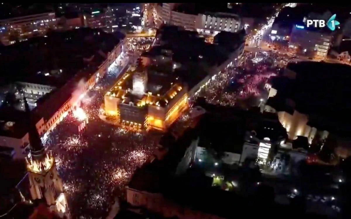 Novi Sad’da seçim zaferi kutlamaları sırasında meydan ve çevresindeki sokakları dolduran kalabalık, gece havadan görüntüleniyor.