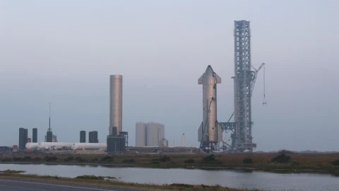 Starship aracı ve fırlatma kulesi, SpaceX’in tesisinde görüntüleniyor.