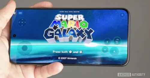 Android telefon ekranında Super Mario Galaxy oyununun açılış ekranı ve dokunmatik kontrol simgeleri görünüyor.