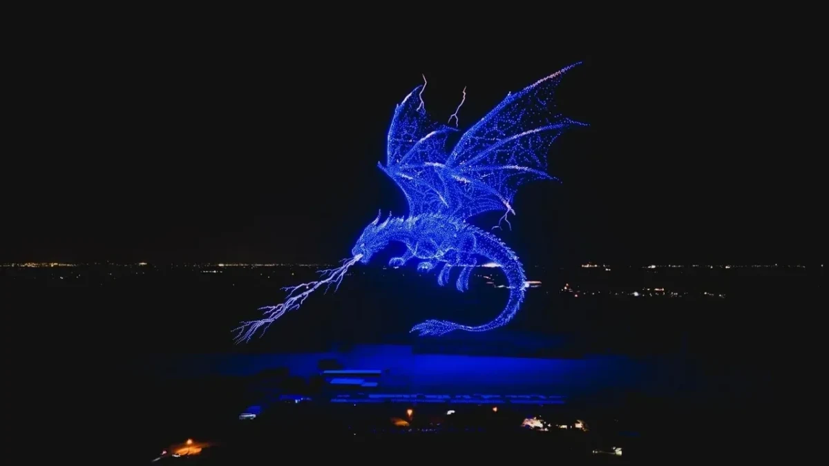 Gece gökyüzünde drone ışıklarıyla oluşturulmuş büyük mavi ejderha figürü